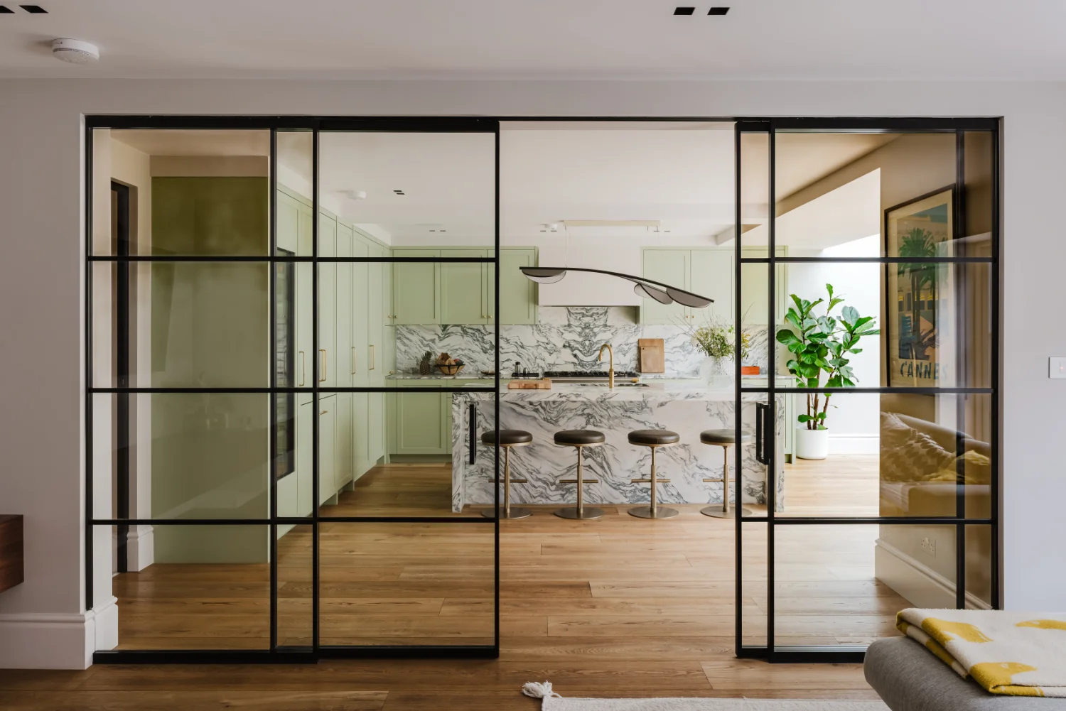 Interior view leading into a contemporary kitchen and dining space in a Westminster residential restoration project.